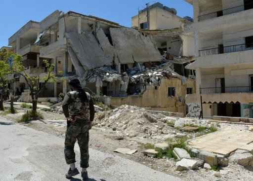Rebelde sírio anda pelos destroços de um prédio em Salma, na província costeira de Latakia, em 26 de abril de 2013. Foto: Miguel Medina/AFP Photo
