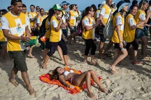 Jovens peregrinos caminham pela praia de Ipanema, no Rio Janeiro, na expectativa da chegada do Papa Francisco para a Jornada Mundial da Juventude. Foto: Yasuyoshi Chiba/AFP Photo