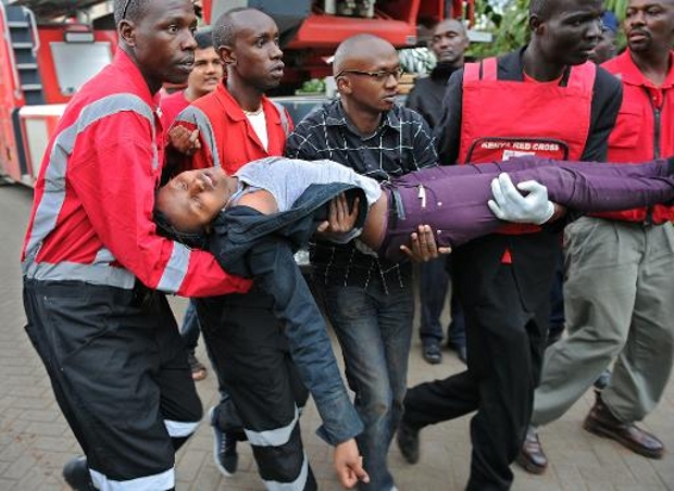 Mulher em choque é carregada depois de ter sido libertada de shopping de Nairóbi.
(AFP/ Tony Karumba)