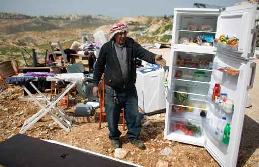 Palestinos recolhem seus pertences depois de terem suas acsas demolidas por Israel, em Beit Hanina, em 19 de março de 2014. Foto: AFP/Arquivos AHMAD GHARABLI