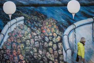 Mulher caminha ao lado da instalação de balões luminosos que representam o traçado do Muro de Berlim, em 8 de novembro de 2014.Foto: © AFP/ODD ANDERSEN (Mulher caminha ao lado da instalação de balões luminosos que representam o traçado do Muro de Berlim, em 8 de novembro de 2014.Foto: © AFP/ODD ANDERSEN)