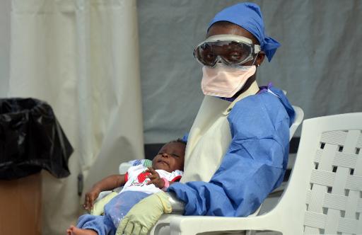 Agente de saúde liberiana cuida de bebê infectado pelo vírus Ebola em 18 de outubro de 2014 na Monróvia - Foto: AFP Zoom Dosso  (AFP Zoom Dosso )