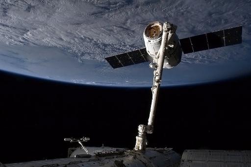 Nave Dragon, da SpaceX, agarrada pelo braço mecânico da Estação Internacional Espacial. Foto: NASA/AFP/Arquivos Chris Hadfield 